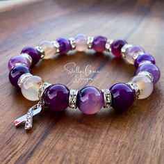 *FREE SHIPPING Our awareness bracelets are perfect for showing support and raising consciousness for a cause while still being stylish. The color purple represents many conditions like Lupus, Epilepsy, Sjögren's Syndrome, Rett Syndrome, Alzheimer's, Sarcoidosis, Macular Degeneration, Cystic Fibrosis, Chronic Migraines, Fibromyalgia, and Chiari Malformations among many more.   This elastic bracelet has 10mm purple banded agate beads, silver Czech Crystal spacer beads, and a silver rhinestone ribb Raising Consciousness, Migraine Awareness, Rett Syndrome, Rhinestone Ribbon, Chronic Migraines, Awareness Bracelet, Purple Agate, Purple Band, Czech Crystal