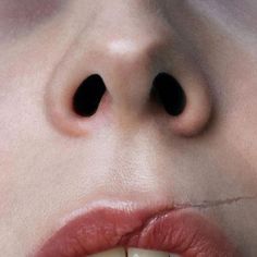 a close up of a person's mouth with black circles on the lip and nose