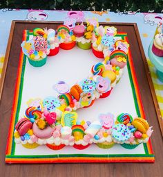 a birthday cake with cupcakes and decorations in the shape of the letter e