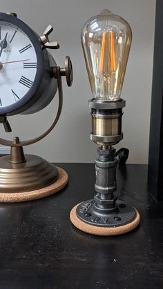 an old fashioned lamp with a light bulb on top of it next to a clock