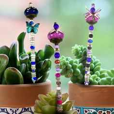 two potted plants are decorated with colorful beads