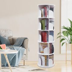 a living room with a couch, table and bookshelf on the floor in front of a window