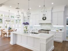 a large kitchen with white cabinets and an island