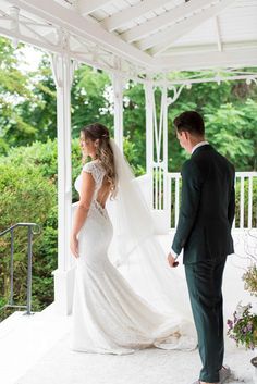 a bride and groom standing under a gazebo