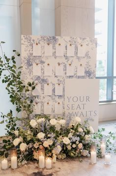 a table topped with flowers and candles next to a sign