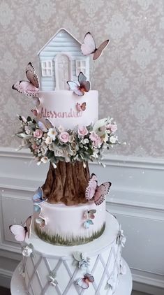 a three tiered cake with flowers and butterflies on it