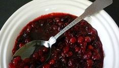 a white bowl filled with cranberry sauce and a spoon