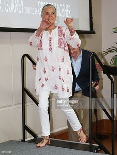 an older woman standing in front of a projector screen with her hand on her hip