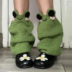 a close up of a person's legs wearing crocheted shoes with flowers on them