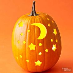 an orange pumpkin with stars and the moon painted on it's side, sitting in front of an orange background