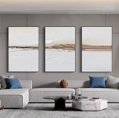 three paintings hang on the wall in a living room