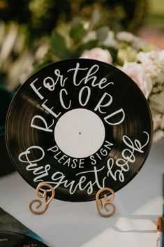 a record sitting on top of a table next to some flowers and other things in front of it