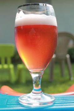 a glass of beer sitting on top of a blue table