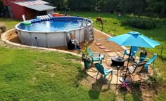 an above ground pool surrounded by lawn chairs and umbrellas with horses grazing in the background