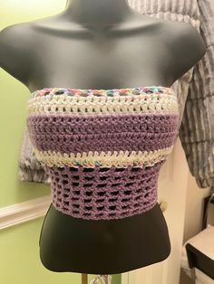 a mannequin wearing a purple and white crochet top with multicolored beads