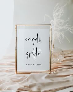 a sign that says cards and gifts on it next to a vase with dried flowers