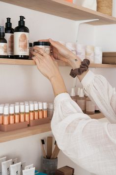 a woman is looking at some products on shelves