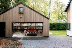 a car is parked in front of a garage with its doors open and windows opened