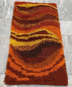 an orange and yellow area rug on the floor