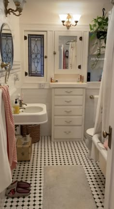 a white bathroom with black and white checkered flooring