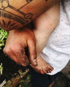 a man holding onto his left hand with tattoos on it