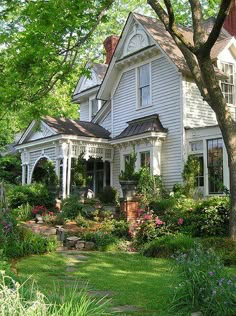 a large white house surrounded by trees and bushes