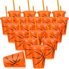 many orange cups with straws in them are lined up