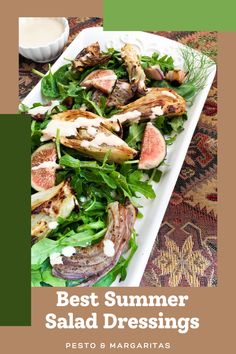 a white plate filled with salad and meat on top of a table next to a bowl of dressing