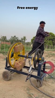 a man standing next to a machine that is spinning on it's back wheels