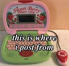 a green and pink laptop computer sitting on top of a white counter next to a red mouse