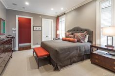 a bedroom with a large bed, dresser and mirror in it's center area