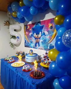 a birthday party with blue and gold balloons, sonic the hedgehog cake and other decorations