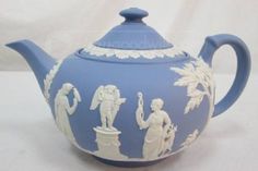 a blue and white tea pot with figures on it