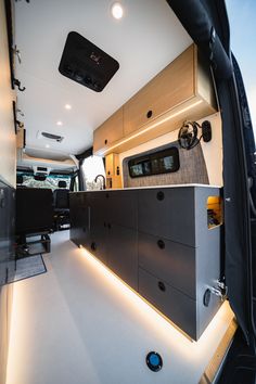 an interior view of a camper van with the door open and drawers lit up