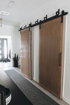 two wooden sliding doors in a room with black carpet and rugs on the floor