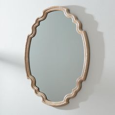 an oval mirror hanging on the wall