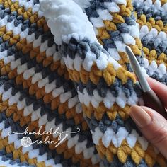 someone is crocheting a blanket with yarn