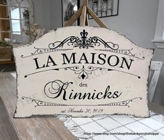 a sign that says la maison des kinnicks hanging on a wall in a room