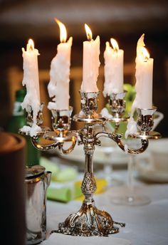 a candelabra filled with lit candles on top of a table