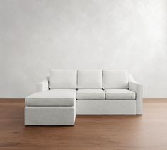 a white couch sitting on top of a hard wood floor next to a wooden floor