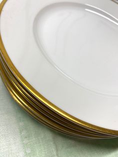 four white and gold plates stacked on top of each other