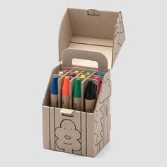 a cardboard box filled with markers and pens