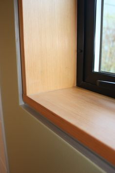 an empty window sill in the corner of a room with wood trimmings