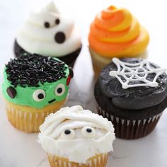 four cupcakes decorated with different types of frosting