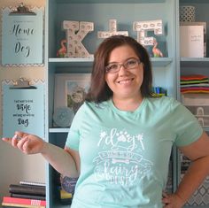 a woman standing in front of a book shelf holding her hand out to the side