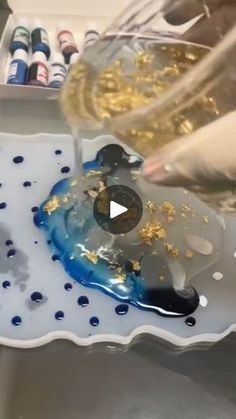 someone is pouring something into a bowl with gold flakes