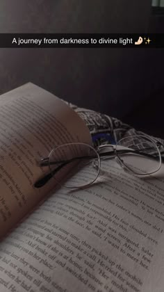 an open book with glasses on top of it