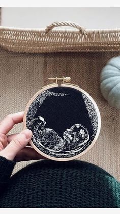 someone is holding up a hand embroidery project