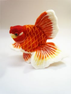 an orange and white fish toy sitting on top of a table