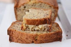 slices of banana bread sitting on top of a white cutting board next to a knife